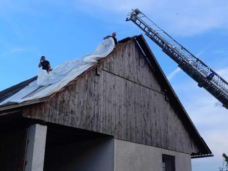 Gasilci med prekrivanjem razkrite strehe